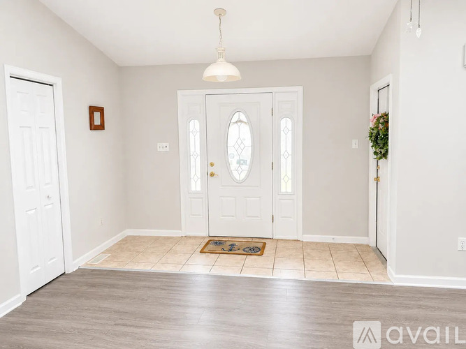 A room with a white door and a rug on the floor.