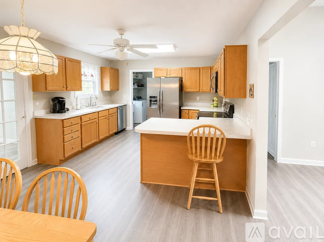 A kitchen with wooden chairs and a table.
