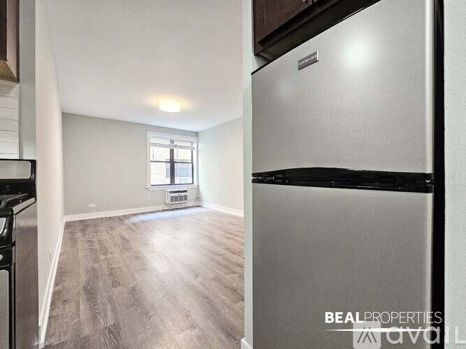 A kitchen with a refrigerator and a window.