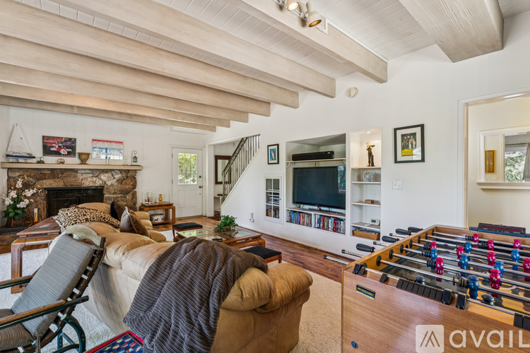 A living room with a foosball table and a fireplace.