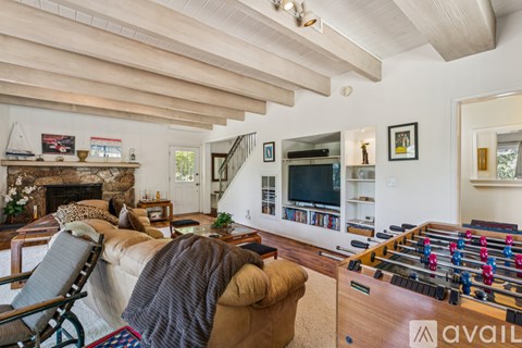 A living room with a foosball table and a fireplace.