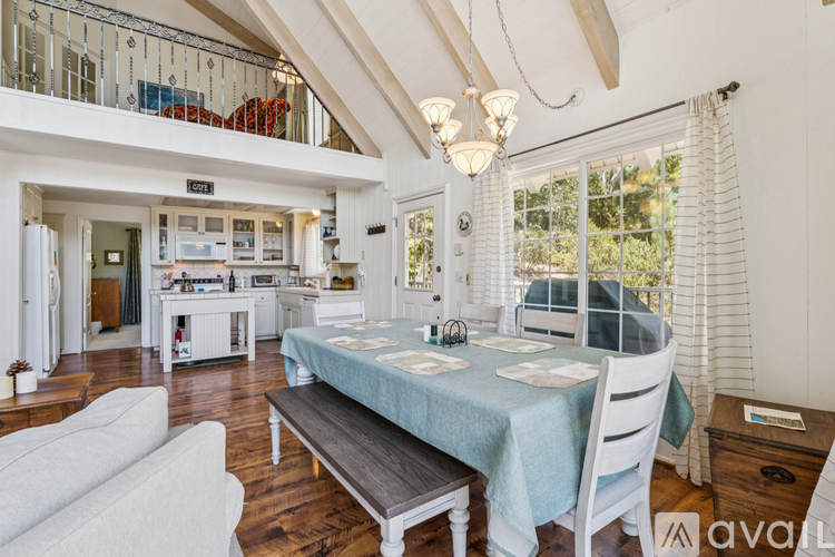 A dining area with a table set for two and a couch.