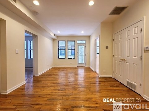 A spacious room with wooden floors and white walls.