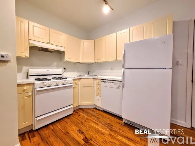 A kitchen with wooden floors and white appliances.