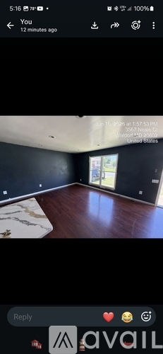 A room with wooden flooring and a large window.