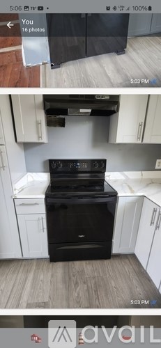 A black oven in a kitchen with white cabinets.