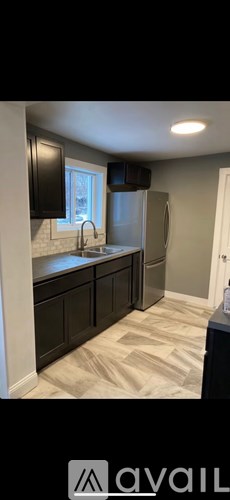 A kitchen with black cabinets and a tiled backsplash.