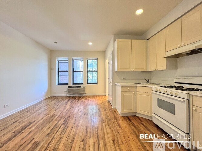 A kitchen with wooden floors and white appliances.