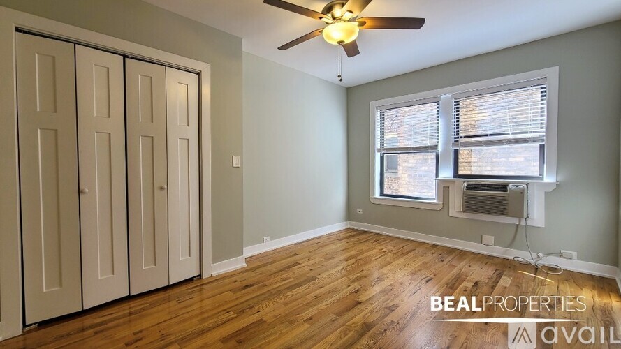 A room with a ceiling fan and a window with blinds.