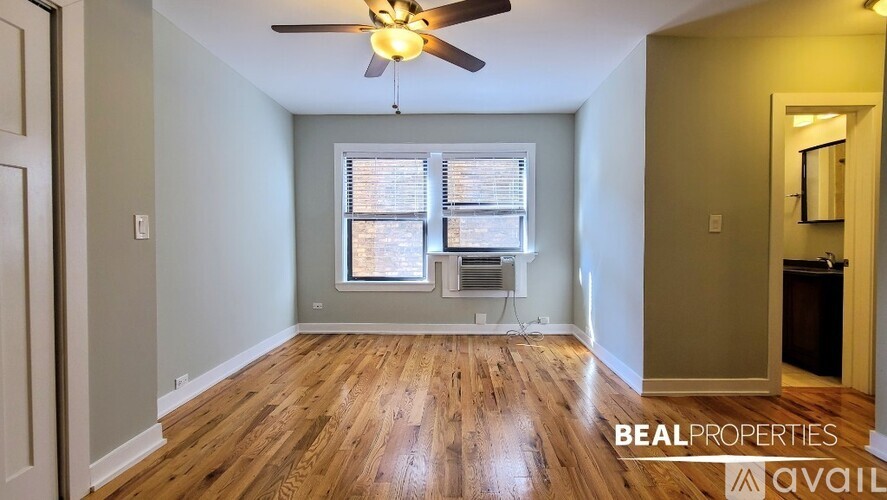 A room with wooden floors and a ceiling fan.