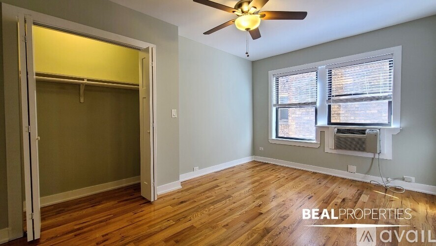 A room with a ceiling fan and a window with blinds.