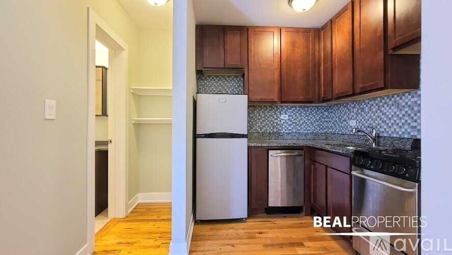 A kitchen with wooden cabinets and a white fridge.