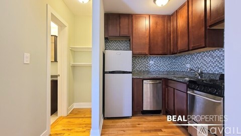 A kitchen with wooden cabinets and a white fridge.