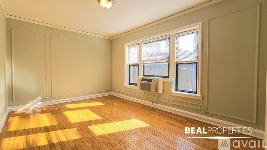 A room with wooden floors and a window with blinds.