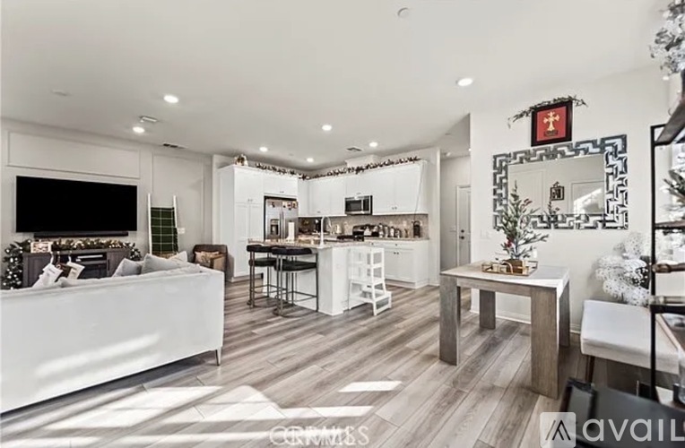 A modern living room with a white sofa and a kitchen area in the background.