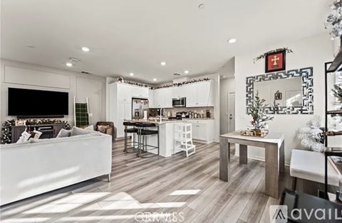 A modern living room with a white sofa and a kitchen area in the background.