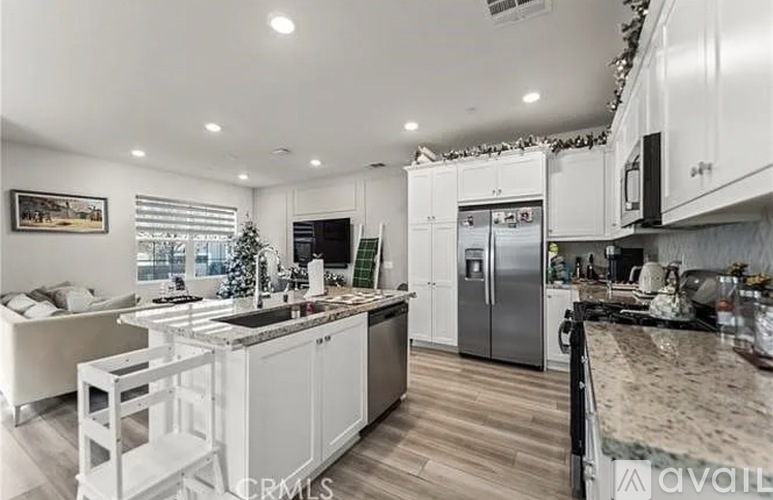A modern kitchen with white cabinets and a marble countertop.