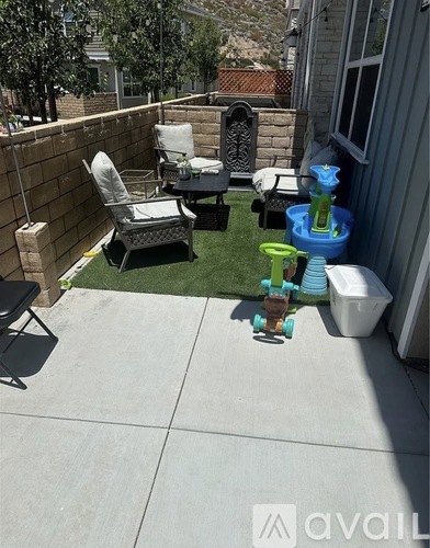 A small patio with a chair, table, and a toy truck.