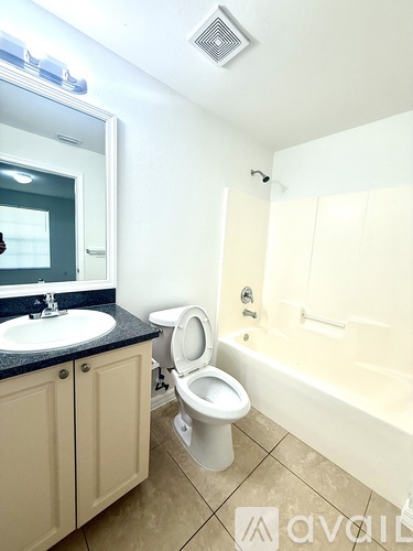 A bathroom with a toilet, sink, and bathtub.