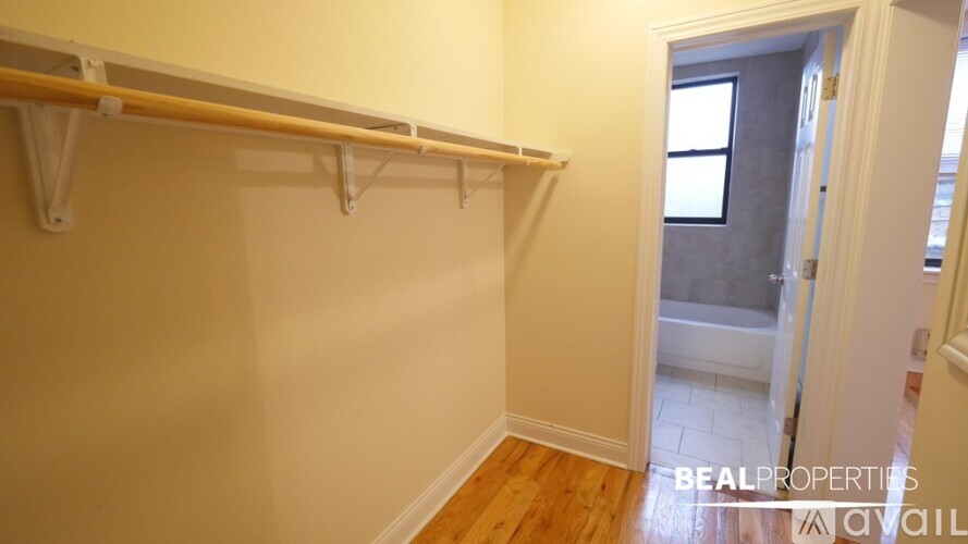 A room with a white wall and a wooden floor with a white door.