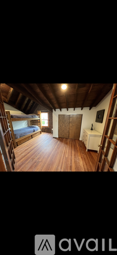 A room with wooden floors and a ladder.