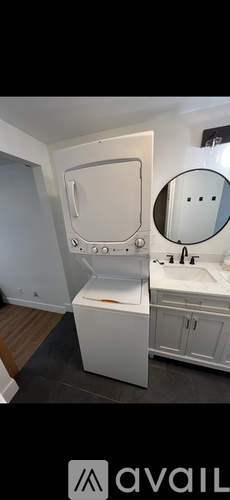 A white bathroom with a toilet, sink, and mirror.