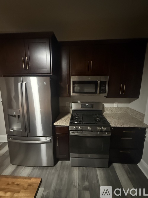 A kitchen with a stainless steel refrigerator, microwave, and oven.