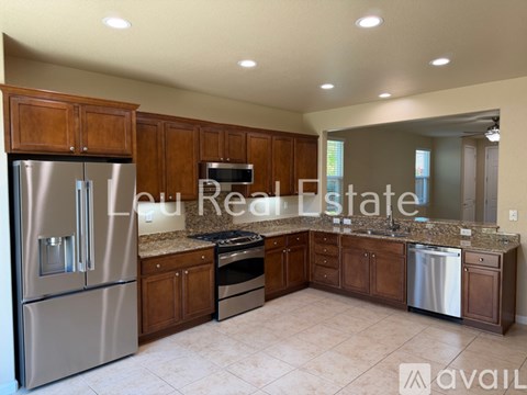 A kitchen with wooden cabinets and stainless steel appliances is available for rent.