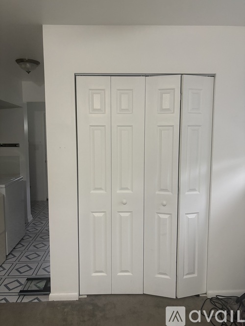 A white door with four panels stands in a room.