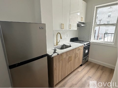 A kitchen with a stainless steel refrigerator and wooden cabinets.