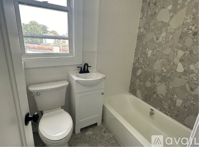 A bathroom with a toilet, sink, and bathtub.