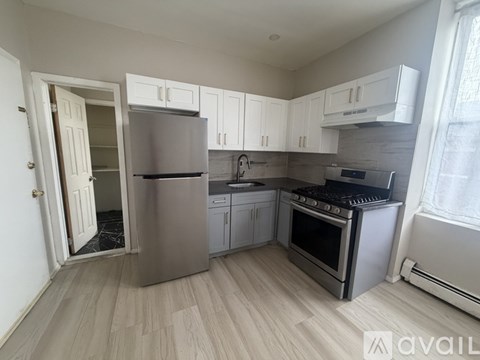 A kitchen with a refrigerator, oven, and cabinets.