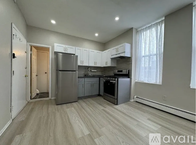 A kitchen with a refrigerator, oven, and cabinets.