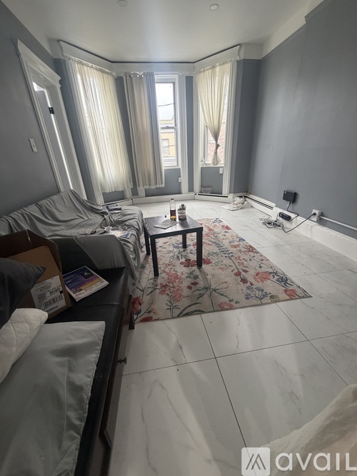 A living room with a couch, a rug, and a television.