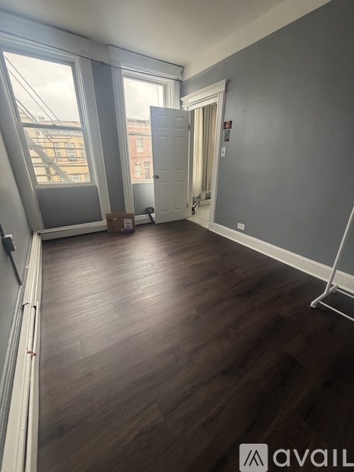 A room with wooden flooring and a large window.