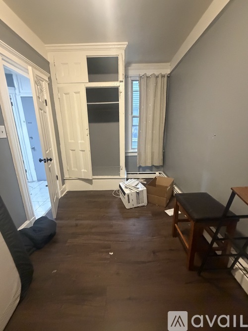 A room with a white door and a window with curtains.
