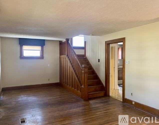 A room with a wooden staircase and a window.