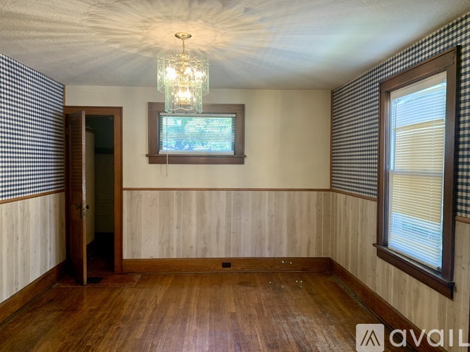 A room with wooden floors and a checkered wallpapered wall.