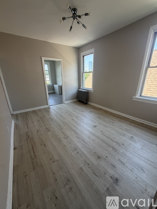 A room with wooden flooring and a ceiling fan.
