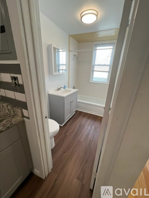 A bathroom with a toilet, sink, and mirror.