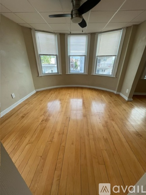 A room with wooden flooring and a ceiling fan.