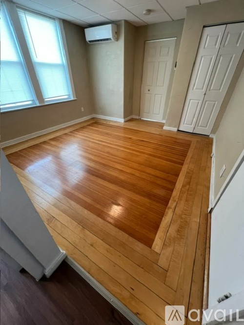 A room with wooden flooring and white walls.