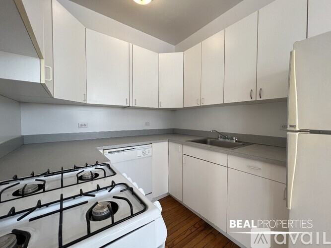 A white kitchen with a stove and cabinets.