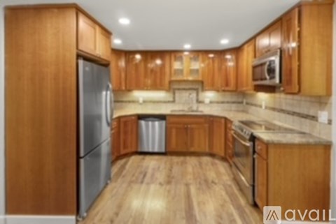 A kitchen with wooden cabinets and a refrigerator.