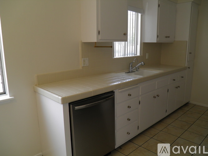 A kitchen with white cabinets and a dishwasher.