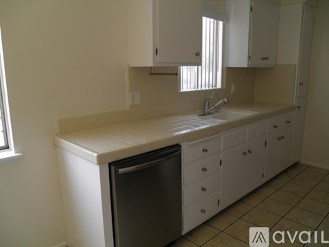 A kitchen with white cabinets and a dishwasher.