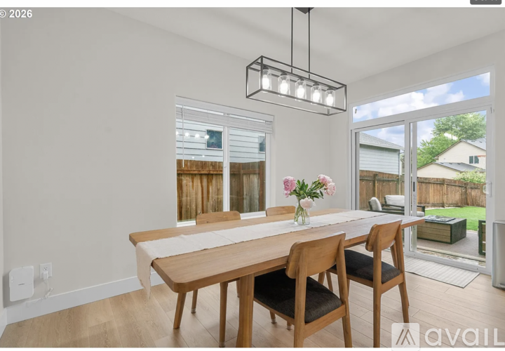 A dining room with a wooden table and chairs.