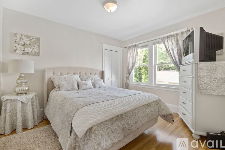 A bedroom with a large bed and a white dresser.