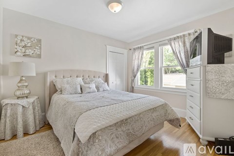 A bedroom with a large bed and a white dresser.