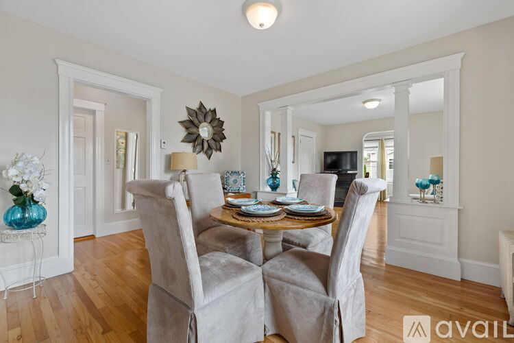 A dining room with a table set for four and chairs surrounding it.
